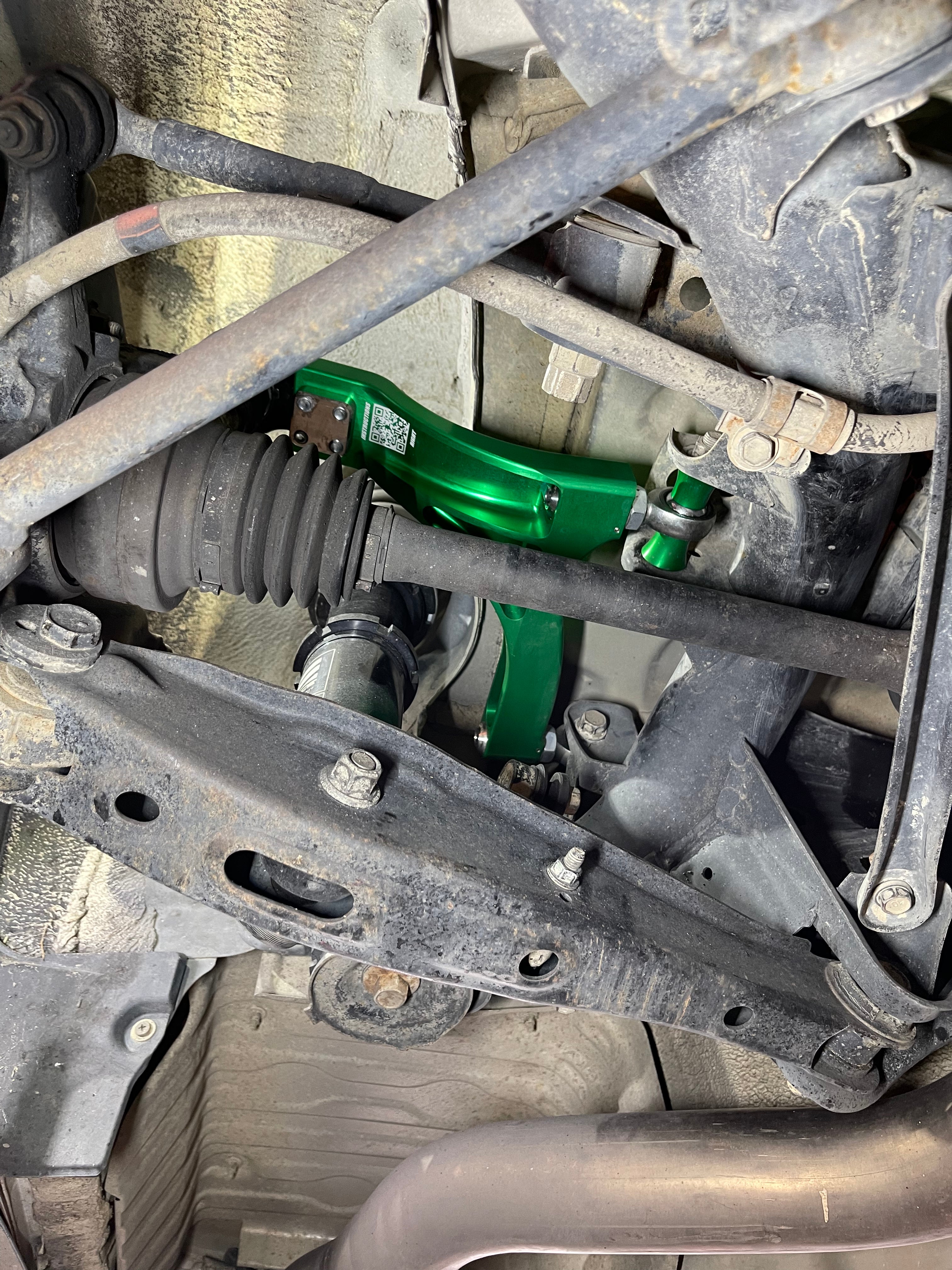 Installed SERIAL999 rear upper control arm, showcasing its fit and function in a vehicle for performance enhancement.