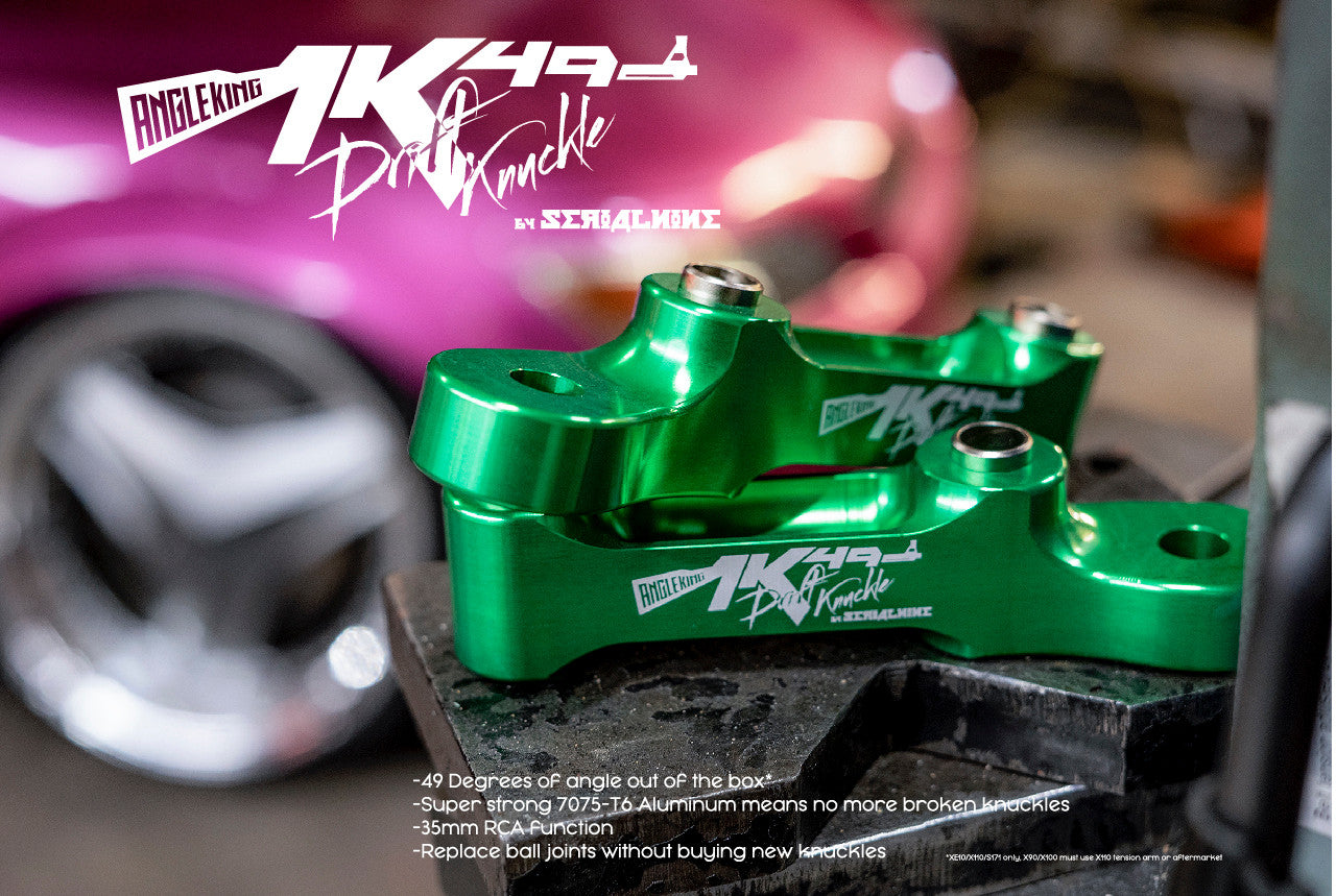  Close-up of green SERIALNINE AK49 Drift Knuckle with sleek design and laser-etched logos, against a blurred pink car. 